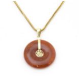 A 14ct gold pendant set with jade roundel Approx 1" long, on a 9ct gold chain 16" long Please Note -