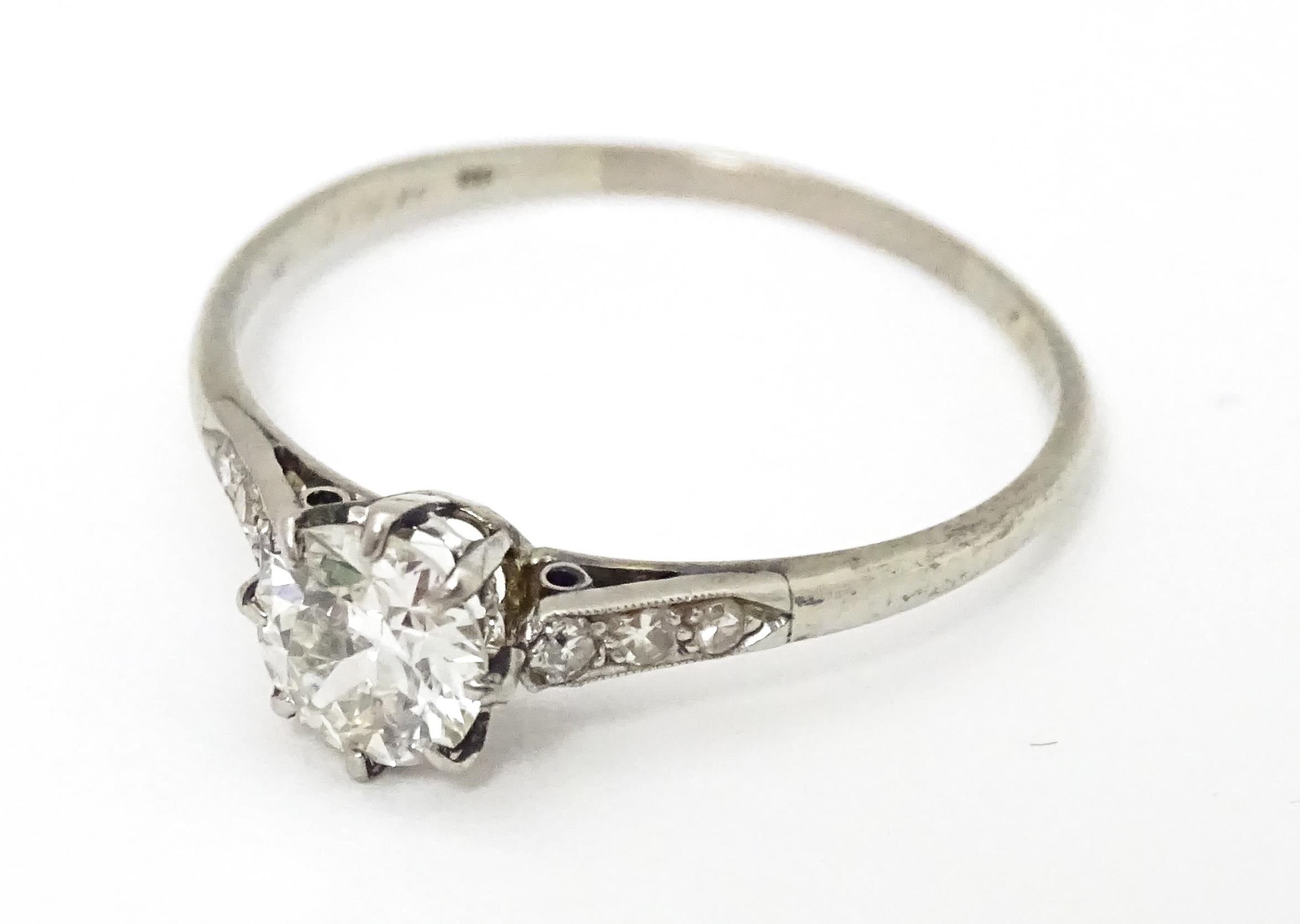 A 18ct white gold ring set with diamond solitaire ring flanked by 3 diamonds to the shoulders. - Image 2 of 7