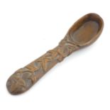 A Victorian carved wooden treen spoon with stylised vine leaf decoration, signed J. J. 1889 under.