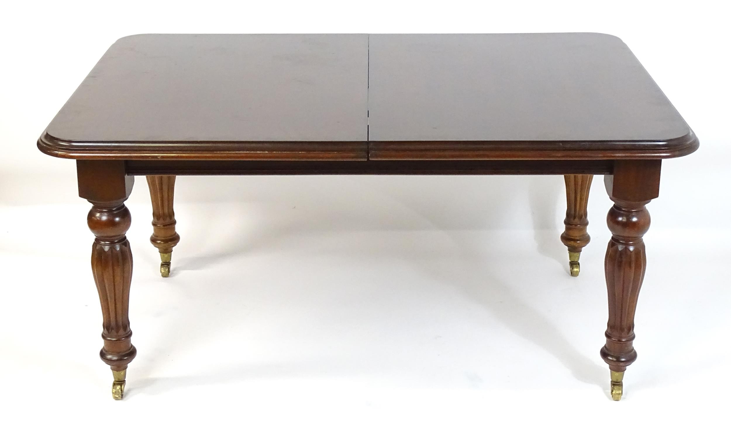 A late 20thC / early 21stC mahogany dining table with a moulded top and rounded corners above reeded - Image 4 of 7