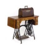 An early 20thC singer sewing machine mounted upon a table, with four short drawers, a drop flap