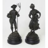 Two 20thC French cast harvest figures, the female figure holding a flask, standing on a naturalistic