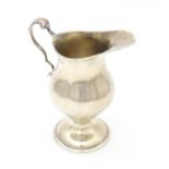 A silver cream jug with loop handle and pedestal foot. Hallmarked Birmingham 1973 maker Bishton's