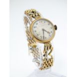A c.1925 9ct gold cast ladies wristwatch, the dial with engraved decoration, Arabic numerals and