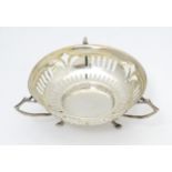 A silver bon bon dish with pierced decoration and three handles raised on three feet. Hallmarked