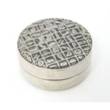 An Egyptian white metal pill box with hieroglyphics decoration to lid. Approx. 1 1/4" diameter