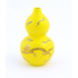 A Chinese double gourd vase with a yellow ground decorated with dragons and a flaming pearl.