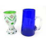 A Bohemian glass goblet with green glass detail and floral decoration together with a blue glass jug