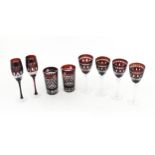 A quantity of Bohemian style ruby red coloured drinking glasses comprising four pedestal wine