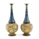 A pair of Doulton Slaters Lambeth bottle vases with mottled blue glaze to neck, the body decorated