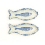 Two Dutch Delft blue and white herring dishes of stylised fish form, with hand painted decoration