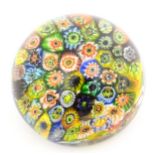 A small glass paperweight with millefiori decoration. Approx. 2 1/2" diameter Please Note - we do
