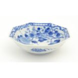 An Oriental blue and white bowl of octagonal form decorated with flowers and blossom, with a