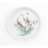 A Chinese plate / dish depicting a figure in landscape with a bat flying overhead. Character marks