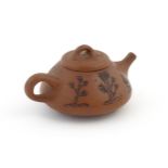 A Chinese Yixing teapot with incised tree and script detail. Character marks under and to underside