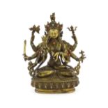 A Tibetan cast bronze figure of Guanyin with eight arms holding various symbols to include ruyi,