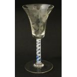 A 19thC pedestal drinking glass with double air twist and etched bird and fruiting vine detail.