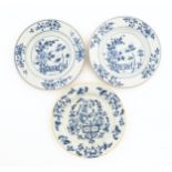 Two Chinese blue and white plates decorated with a peony flower in a garden, with floral border.