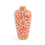 A Chinese vase of baluster form decorated with flowers and blossom on a red ground. Character