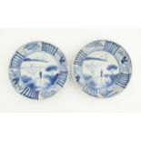 A pair of Oriental blue and white dishes each depicting a figure on a bridge looking out to sea with