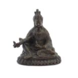 A Tibetan cast bronze model of the Buddhist master Padmasambhava / Guru Rinpoche seated holding