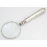 A silver handled magnifying glass. Approx. 5 1/2" long Please Note - we do not make reference to the