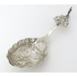 A Dutch silver caddy spoon with embossed decoration. Approx. 4 3/4" long Please Note - we do not