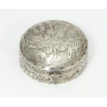 A .925 silver pill box of circular form with engraved acanthus scroll detail. Approx. 1 1/4"