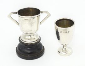 Two miniature silver trophy cups, one with twin handles and a socle base hallmarked Birmingham 1906,