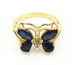 A 9ct gold ring set with sapphires and diamond in a butterfly setting. Ring size approx. M 1/2