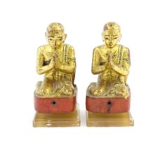 A pair of Asian carved wooden models of Buddhist monks in prayer with gilt detail. Approx. 8 1/4"