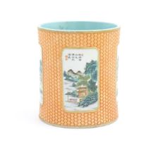 A Chinese brush pot of cylindrical form with relief basket weave detail and hand painted landscape