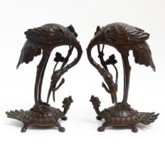 A pair of Japanese cast sculptures modelled as a stylised crane standing on a tortoise. Approx. 7