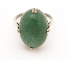 An Art Deco white metal ring set with green stone cabochon. Ring size approx. N. Please Note - we do