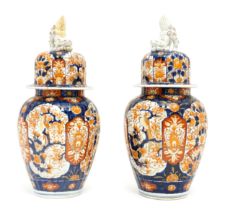 A pair of Japanese lobed lidded vases decorated with birds, fans, flowers and foliage in the Imari