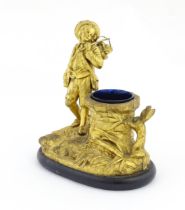 A late 19th / early 20thC gilt bronze figural spill vase modelled as a young man holding a basket of