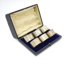 A cased set of six silver napkin rings with engine turned decoration hallmarked Birmingham 1912,