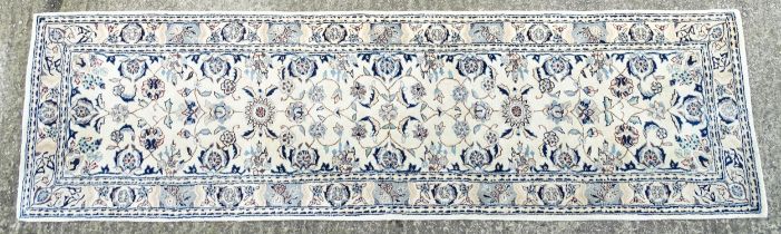 Carpet / Rug : A beige ground runner with floral and foliate detail worked in shades of blue.