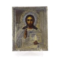 A 19thC Russian oil on panel icon depicting Christ Pantocrator with an embossed silver surround with