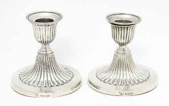 A pair of Victorian short candlesticks with fluted decoration hallmarked Sheffield 1882, maker