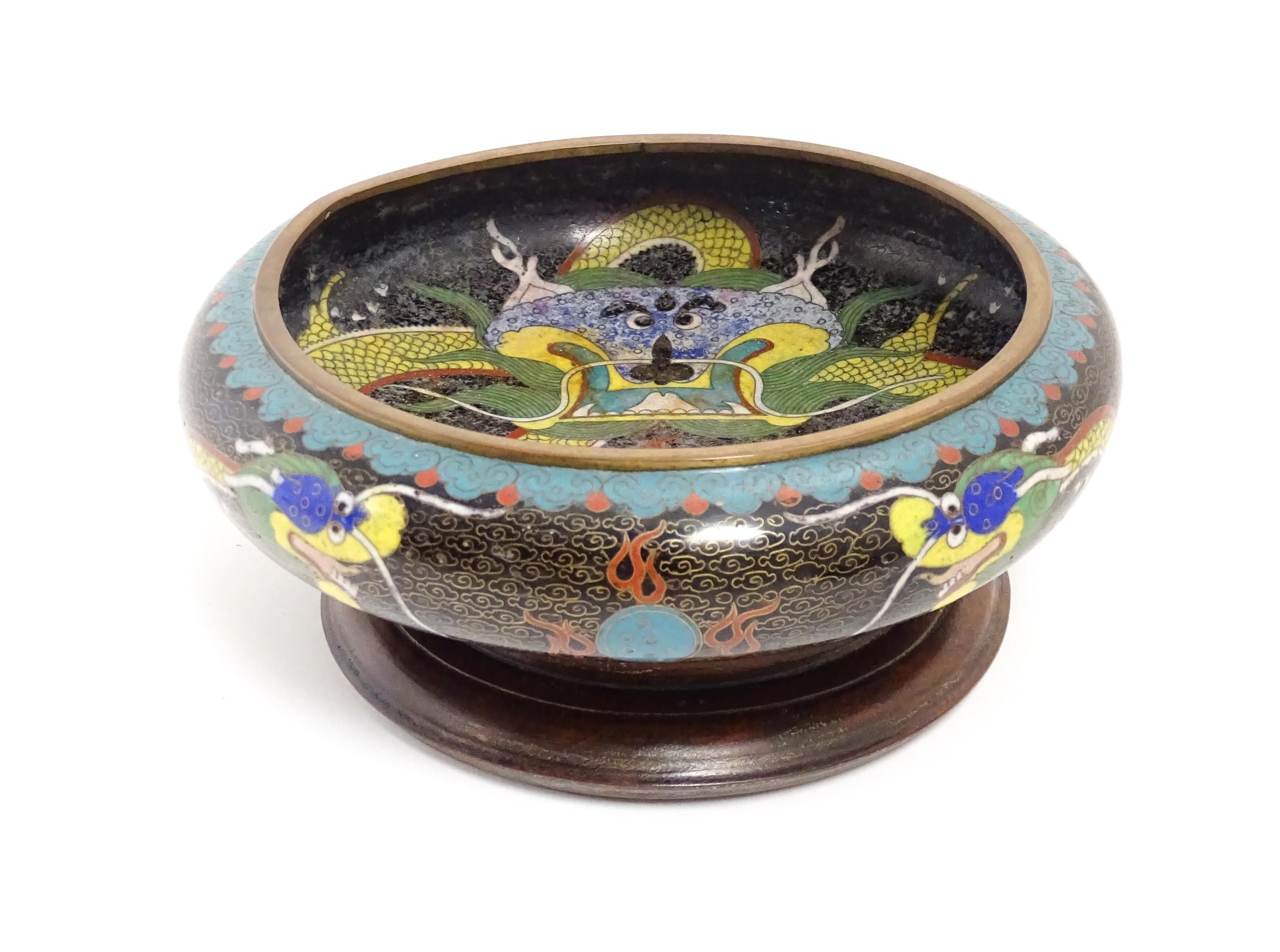A Chinese cloisonne dish the black ground with dragon and flaming pearl decoration. Character