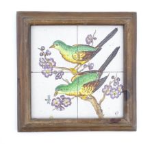 Four hand painted tiles framed together depicting two birds perched on a branch with blossom. Signed