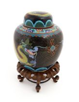 A Chinese cloisonne ginger jar with a black ground decorated with dragons and a flaming pearl.