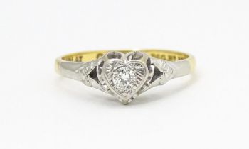 An 18ct gold ring with platinum set diamond within a heart shaped setting, marked with