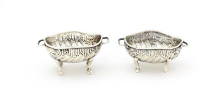 A pair of Continental .930 silver salts with engraved decoration and twin handles raised on four