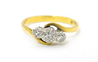 An 18ct gold ring with platinum set diamond trio. Ring size approx. N Please Note - we do not make