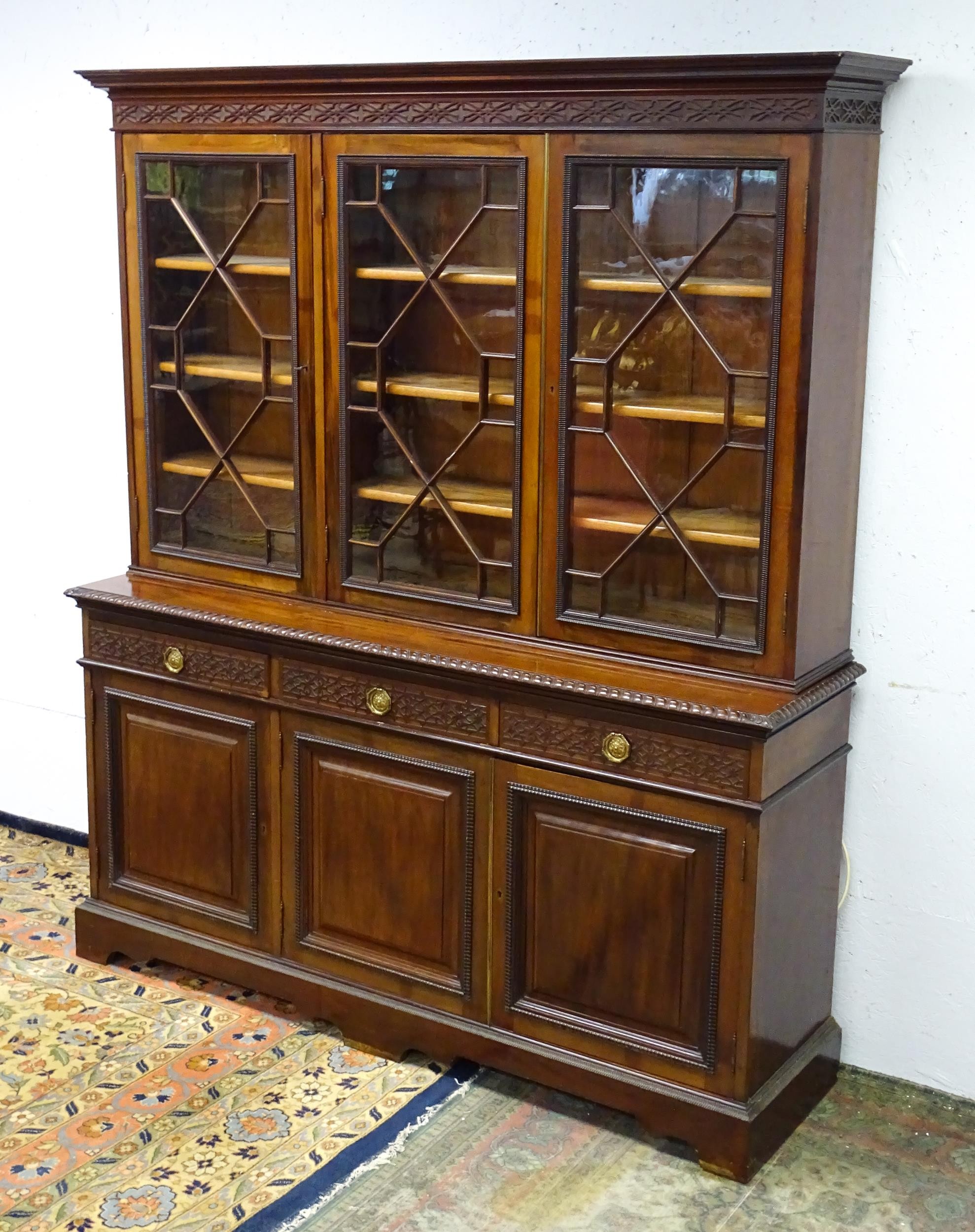 A late 19thC mahogany glazed bookcase by S & H Jewell, Queen Street, London. The cornice with