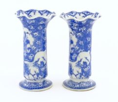 A pair of Oriental blue and white vases with lobed flared rims, decorated with flowers and