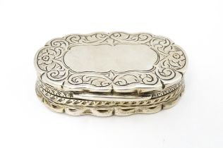 A silver pill box with engraved decoration hallmarked Birmingham 1920, maker George Randle.