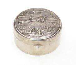 A .925 silver pill box of circular form decorated to lid with images of an aeroplane, airship,
